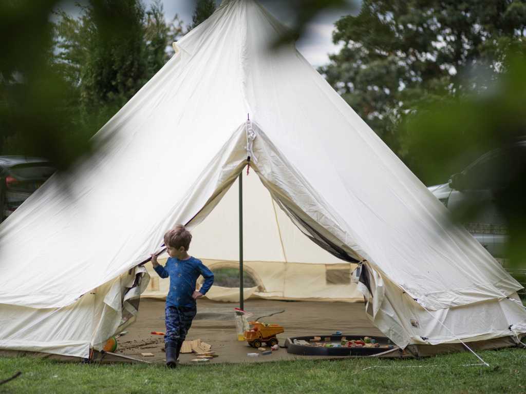 Forest school tent with child running outside at Sinai Forest School